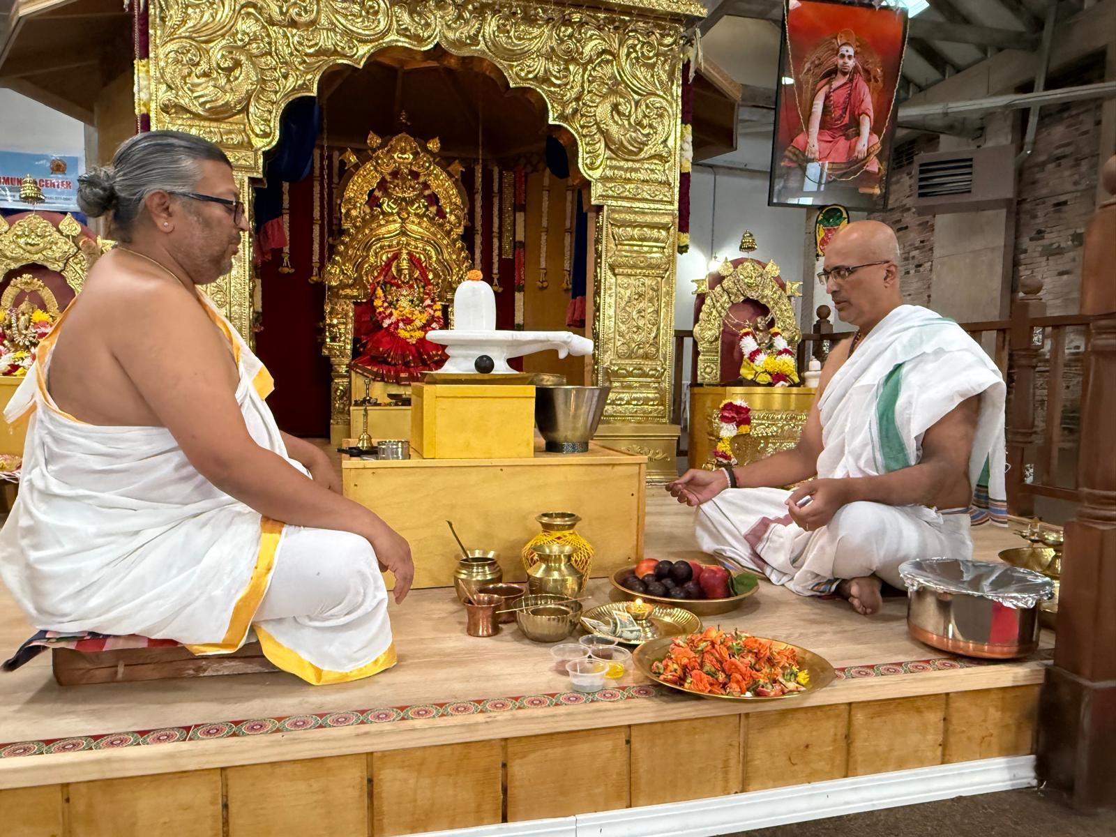 Priests performing abhishekam at the shrine