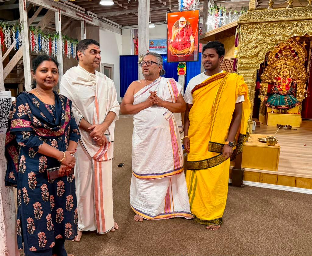 Four devotees standing in front of the shrine