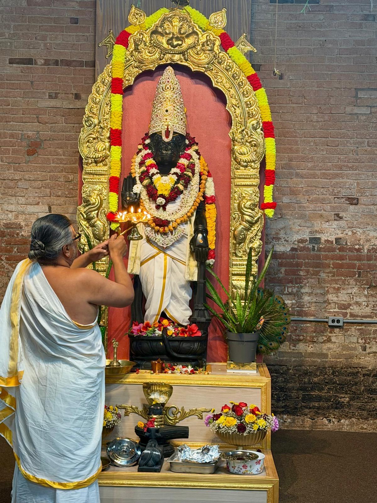 Priest performing puja at the shrine