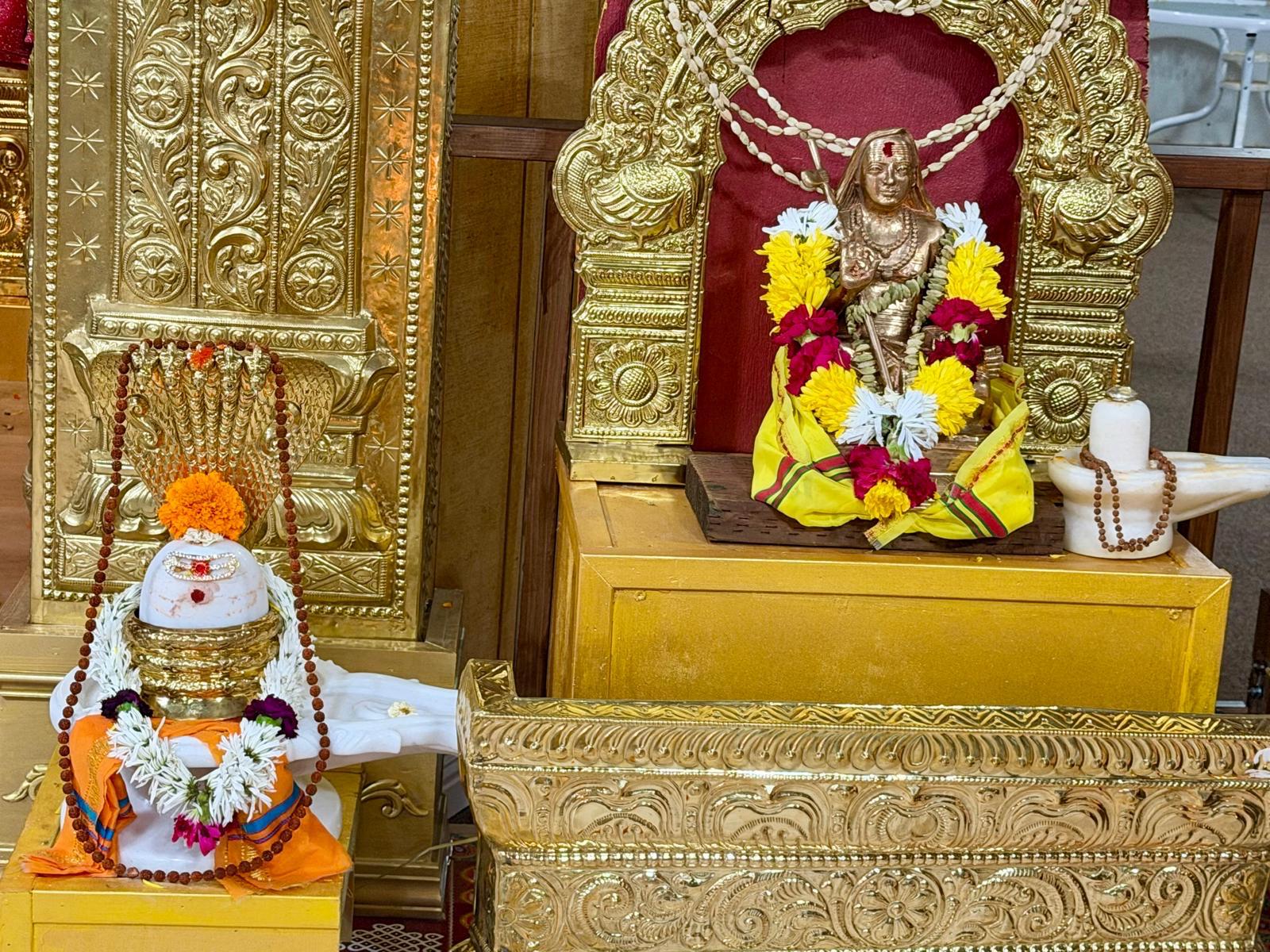 Decorated shrine with a kalasha and flower garlands